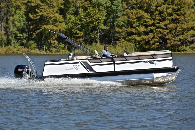 Slide: The Image of 2023 Viaggio L22R pontoon boat cruising on a lake with lush green trees in the background. - 3