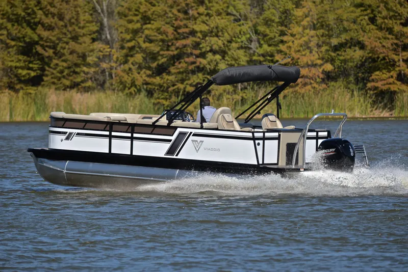Slide: The Image of 2023 Viaggio L22R pontoon boat cruising on a lake with forested background. - 4