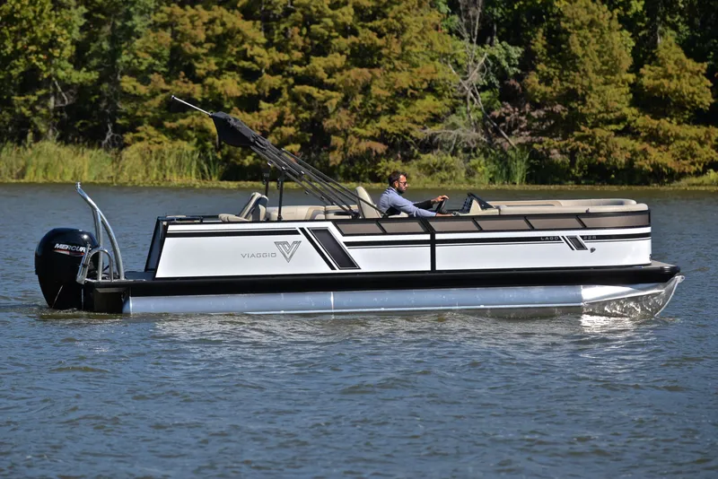 Slide: The Image of 2023 Viaggio L22R pontoon boat cruising on a lake with lush green trees in the background. - 6