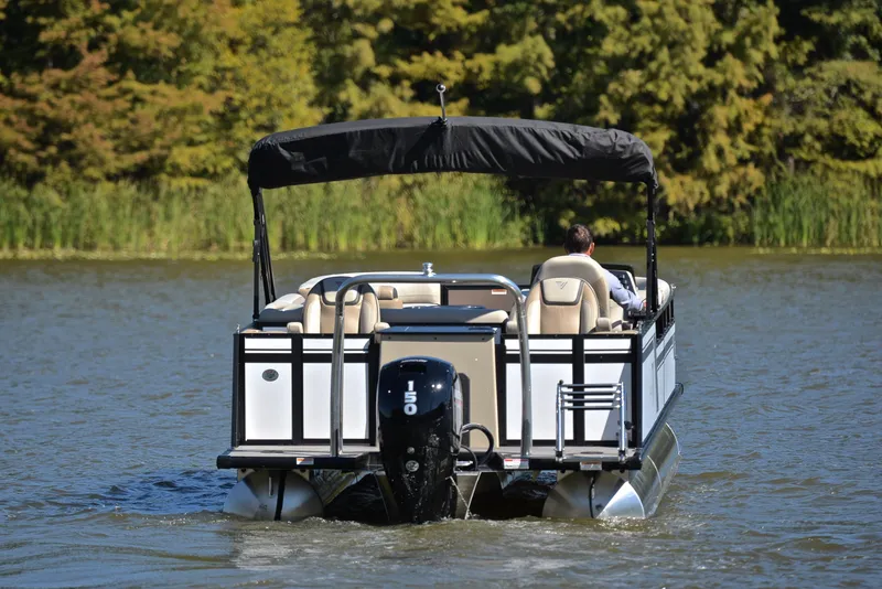 Slide: The Image of 2023 Viaggio L22R pontoon boat cruising on a lake with lush greenery in the background. - 7
