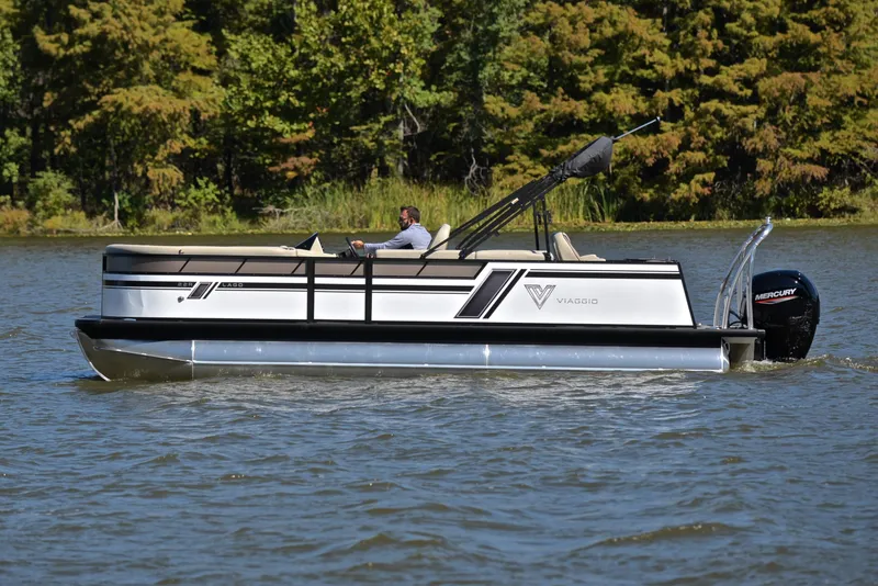 Slide: The Image of 2023 Viaggio L22R pontoon boat cruising on a lake with a forested background. - 8