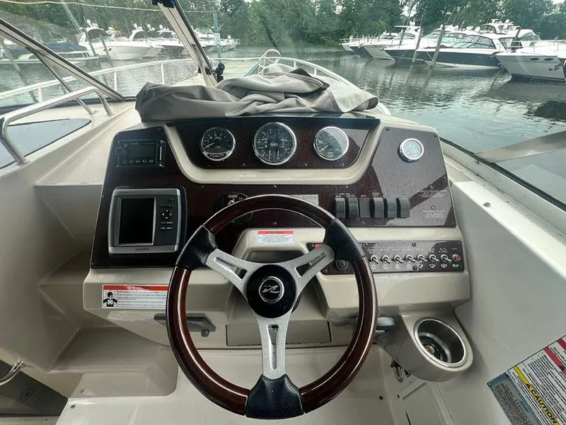 Slide: The Image of 2010 Sea Ray 280 Sundancer helm with steering wheel and control panel. - 10