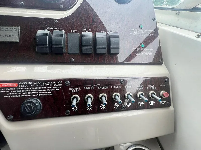 Slide: The Image of Control panel of a 2010 Sea Ray 280 Sundancer boat with various switches and warning labels. - 13