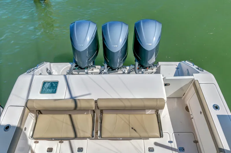 Slide: The Image of 2016 Pursuit 385OS boat with triple outboard engines and cushioned seating. - 11