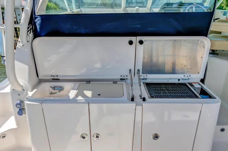 Slide: The Image of 2016 Pursuit 385OS boat with open cockpit storage and sink. - 17