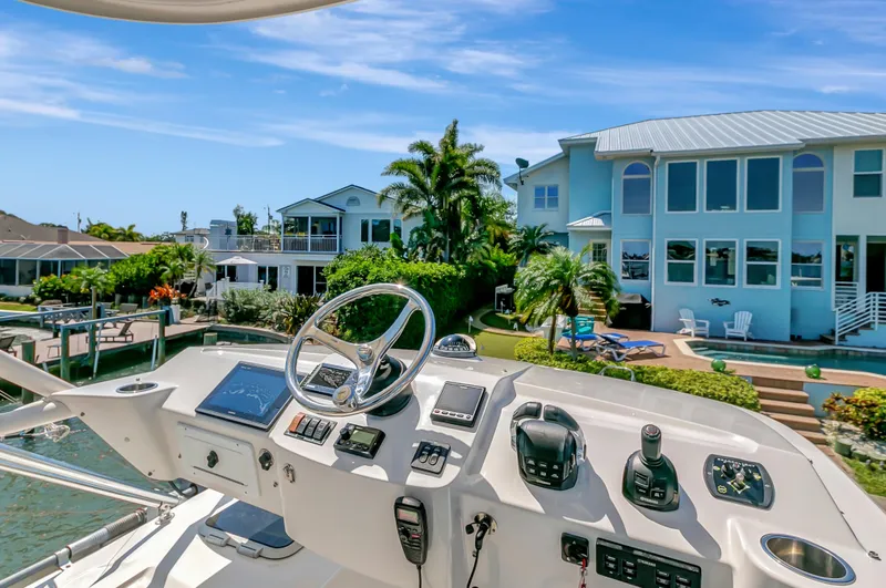 Slide: The Image of Helm of 2016 Pursuit 385OS boat with waterfront homes in the background. - 19