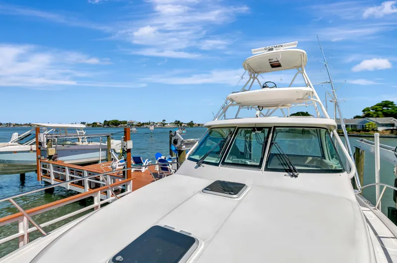 Slide: The Image of 2016 Pursuit 385OS boat docked at a marina on a sunny day. - 20