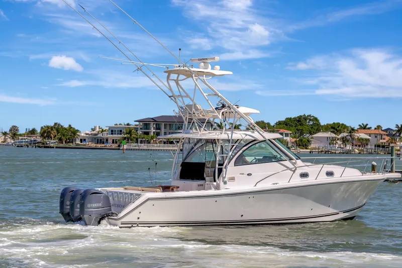 Slide: The Image of 2016 Pursuit 385OS boat cruising on a sunny day near waterfront homes. - 4