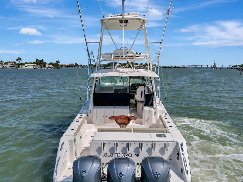Slide: The Image of 2016 Pursuit 385OS boat on water, rear view with triple outboard engines. - 5
