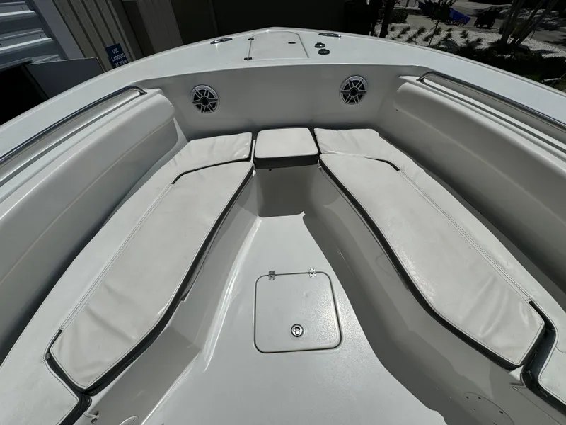 Slide: The Image of 2016 Tidewater 252 CC Adventure boat bow seating area with white cushions. - 26