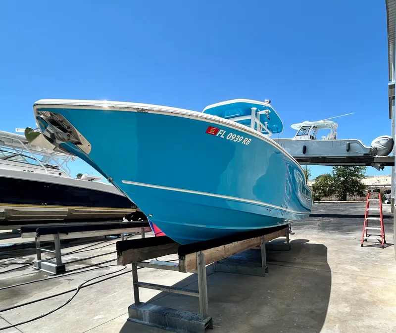 Slide: The Image of 2016 Tidewater 252 CC Adventure boat in dry dock, vibrant blue hull. - 4