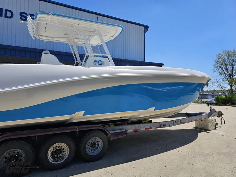 Slide: The Image of 2014 Deep Impact 36 Open boat on a trailer, blue and white hull, parked outdoors. - 4