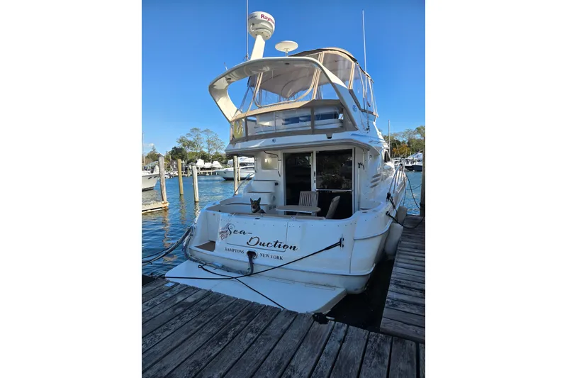 Slide: The Image of 2000 Sea Ray 400 Sedan Bridge yacht docked at marina, clear blue sky. - 3