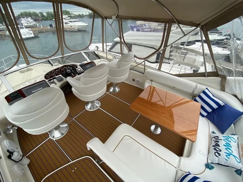 Slide: The Image of Luxurious 2000 Sea Ray 400 Sedan Bridge yacht interior with helm, seating, and waterfront view. - 6
