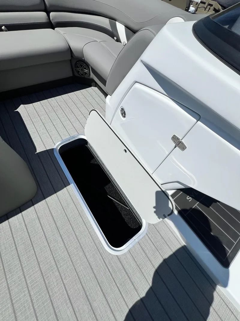 Slide: The Image of 2024 Sylvan S3 CLZ DH Tritoon interior with open storage compartment. - 33