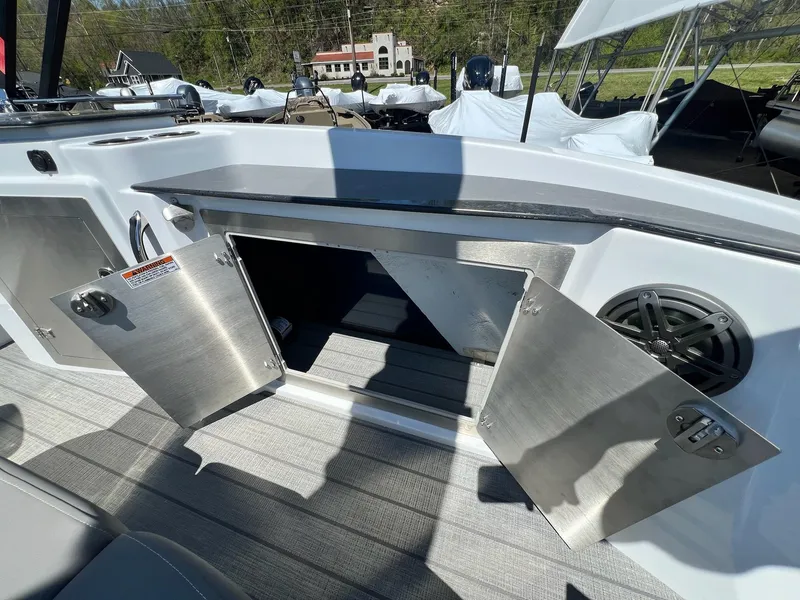 Slide: The Image of 2024 Sylvan S3 CLZ DH Tritoon storage compartment with open stainless steel doors. - 6