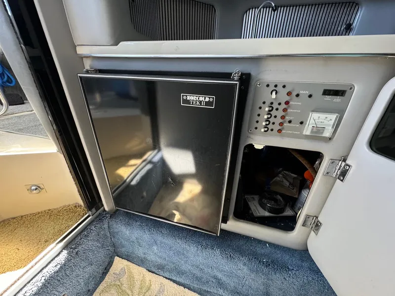 Slide: The Image of 1987 Sea Ray Pachanga 32 interior with fridge and control panel. - 15