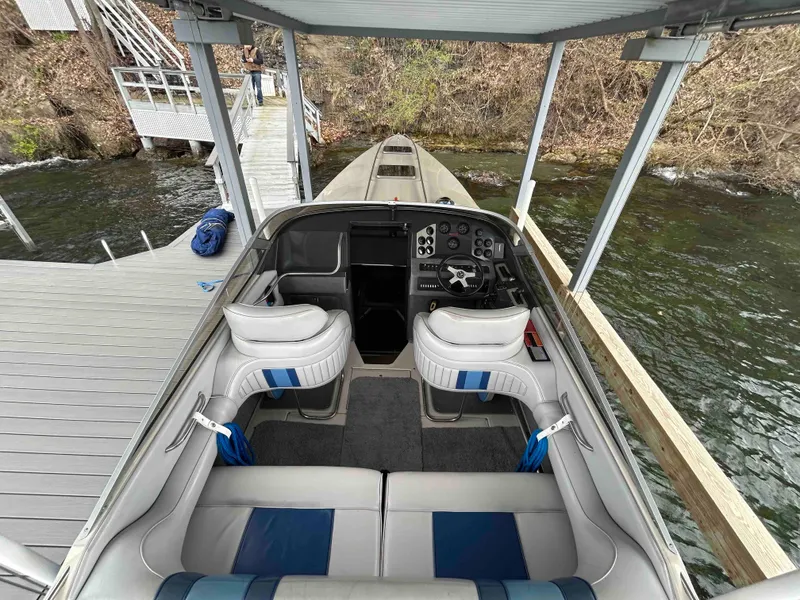 Slide: The Image of 1987 Sea Ray Pachanga 32 boat interior at dock, featuring seating and control panel. - 2
