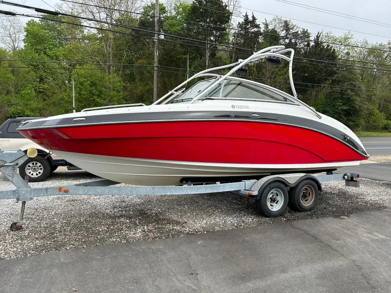 The Image of 2012 Yamaha Boats AR240 on trailer, red and white, side view. - 0