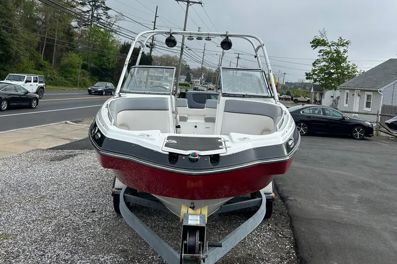Slide: The Image of 2012 Yamaha Boats AR240 on trailer, red and white, parked near road. - 4