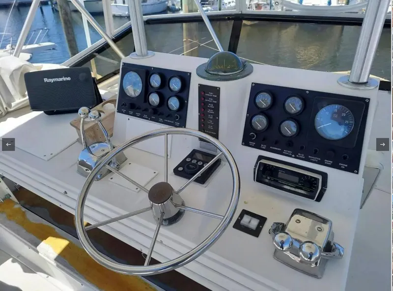 Slide: The Image of 1988 Viking 41 Convertible boat helm with gauges and Raymarine electronics. - 2