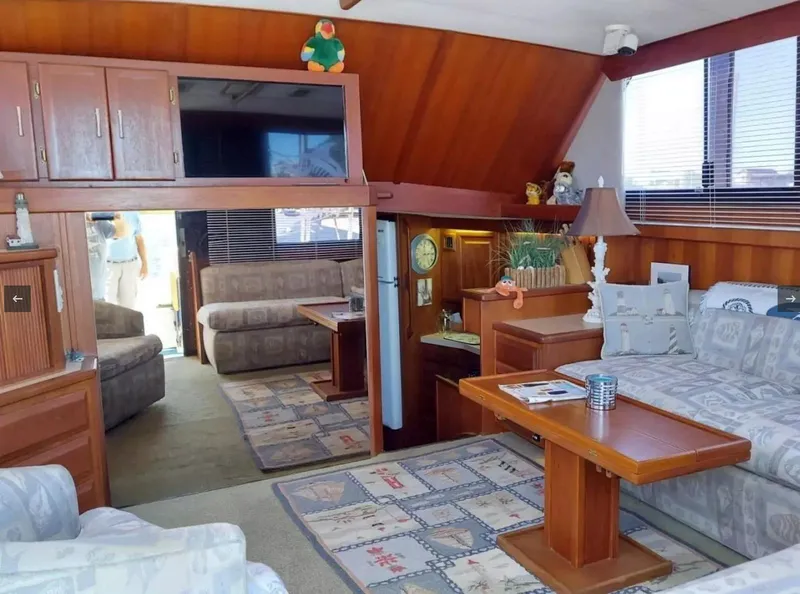 Slide: The Image of Interior of 1988 Viking 41 Convertible yacht with cozy seating and wooden accents. - 7