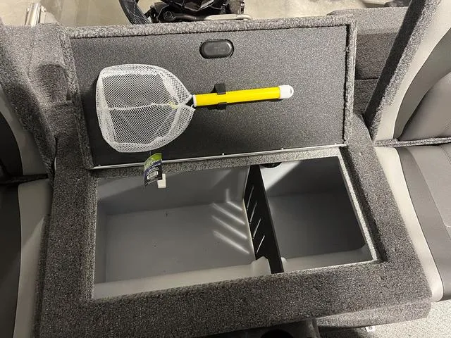 Slide: The Image of 2024 Lund 1775 Impact XS Sport boat storage compartment with a fishing net. - 14