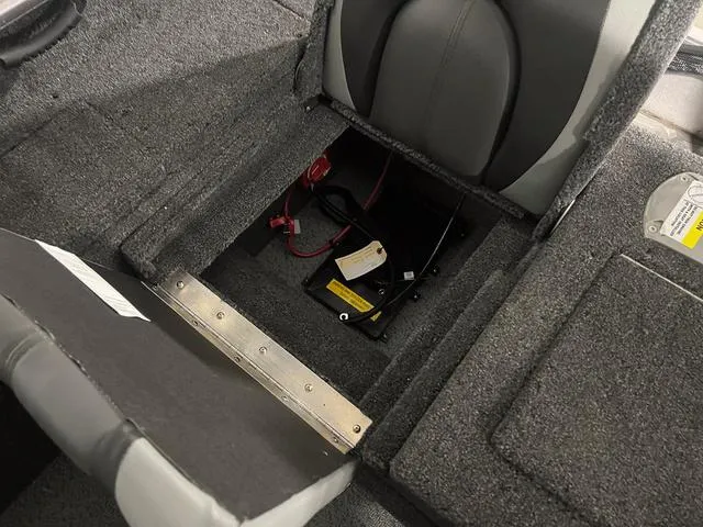 Slide: The Image of 2024 Lund 1775 Impact XS Sport boat interior storage compartment with battery and wiring. - 15