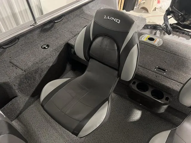Slide: The Image of 2024 Lund 1775 Impact XS Sport boat interior with black and gray seating. - 18