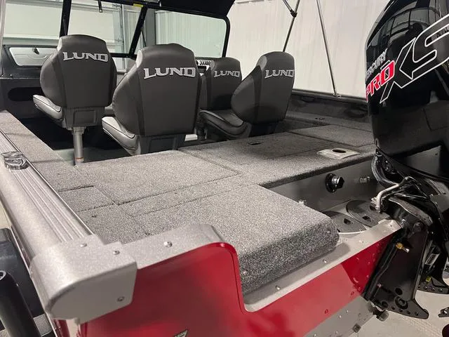 Slide: The Image of 2024 Lund 1775 Impact XS Sport boat interior with seating and motor. - 9