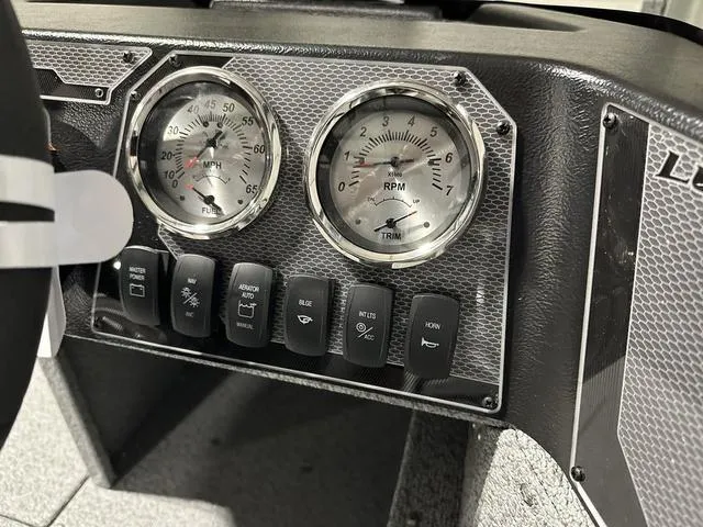 Slide: The Image of 2024 Lund 1875 Alaskan SS dashboard with speedometer, RPM gauge, and control switches. - 15