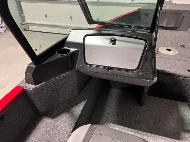 Slide: The Image of 2024 Lund 1650 Rebel XL Sport boat interior with storage compartment and cup holder. - 16
