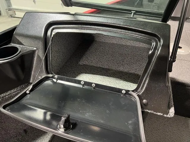 Slide: The Image of 2024 Lund 1650 Rebel XL Sport boat storage compartment with open hatch. - 17