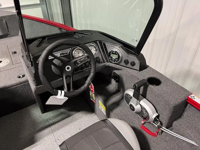 Slide: The Image of 2024 Lund 1650 Rebel XL Sport boat cockpit with steering wheel and control panel. - 19