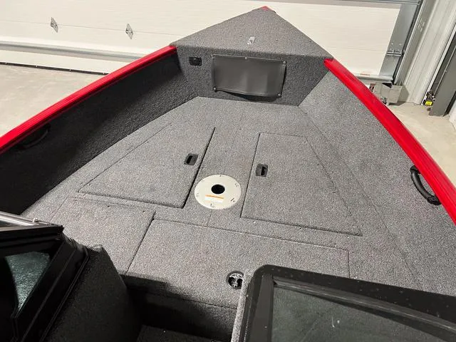 Slide: The Image of 2024 Lund 1650 Rebel XL Sport boat interior with storage compartments and red trim. - 24