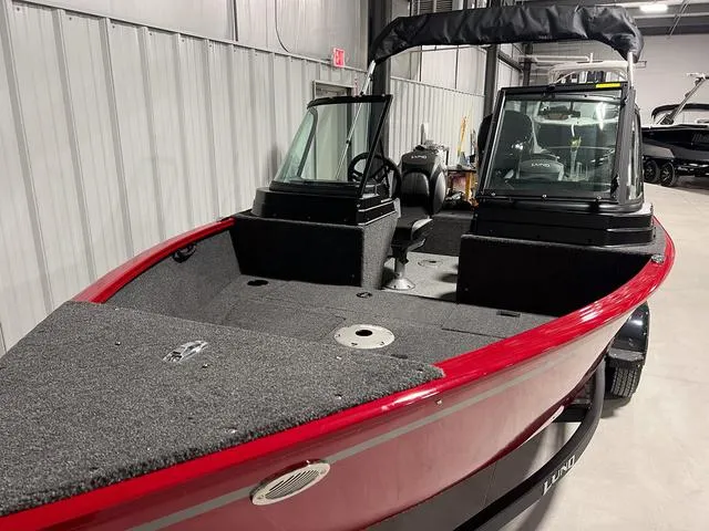 Slide: The Image of 2024 Lund 1650 Rebel XL Sport fishing boat with red exterior in showroom. - 3