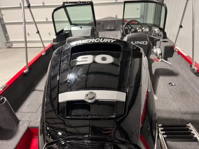 Slide: The Image of 2024 Lund 1650 Rebel XL Sport with Mercury 90 engine in a garage. - 6