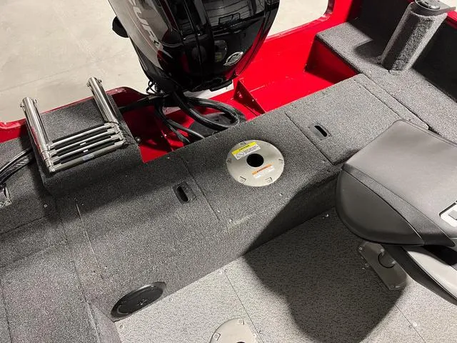 Slide: The Image of 2024 Lund 1650 Rebel XL Sport boat interior with motor and seating. - 7