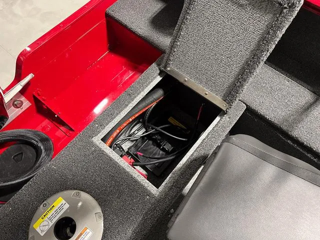 Slide: The Image of 2024 Lund 1650 Rebel XL Sport boat battery compartment and seating area. - 9