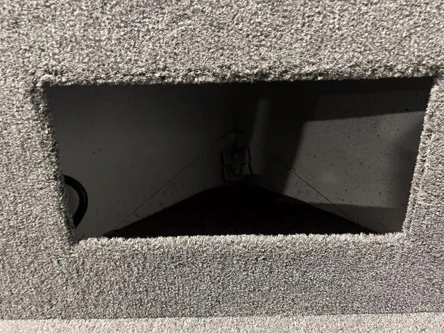 Slide: The Image of 2024 Lund 1600 Fury Tiller storage compartment with grey carpeted interior. - 18