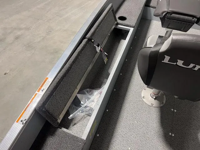 Slide: The Image of 2024 Lund 1600 Fury Tiller boat interior with storage compartment and seating. - 6