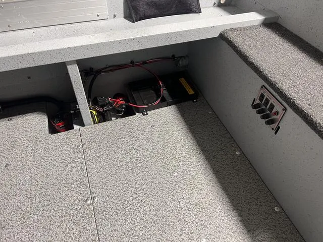 Slide: The Image of 2024 Lund 1600 Fury Tiller boat interior showing battery compartment and wiring. - 8