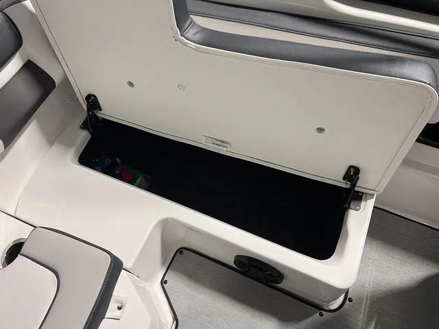 Slide: The Image of 2024 Yamaha Boats SX195 storage compartment with open seat revealing spacious interior. - 11