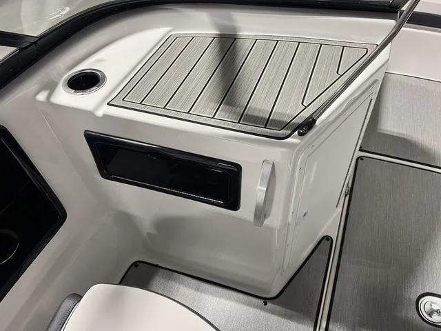 Slide: The Image of 2024 Yamaha Boats SX195 interior detail with storage compartment and cup holder. - 14
