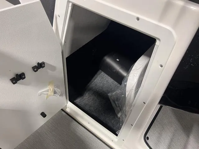 Slide: The Image of Storage compartment of 2024 Yamaha Boats SX195, showcasing interior space and secure latch. - 24