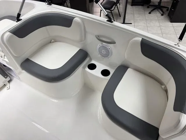 Slide: The Image of 2024 Bayliner E16 LTD boat interior with cushioned seating and cup holders. - 11