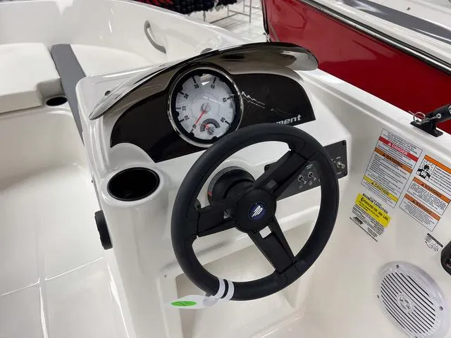 Slide: The Image of 2024 Bayliner E16 LTD boat dashboard with steering wheel and instrument panel. - 16