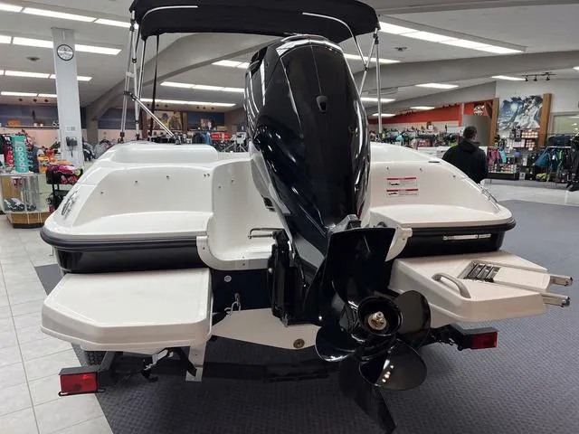 Slide: The Image of 2024 Bayliner E16 LTD boat displayed indoors, rear view with outboard motor. - 5