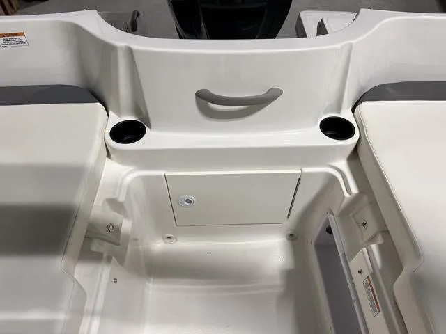 Slide: The Image of 2024 Bayliner E18 LTD boat interior with storage compartment and cup holders. - 10