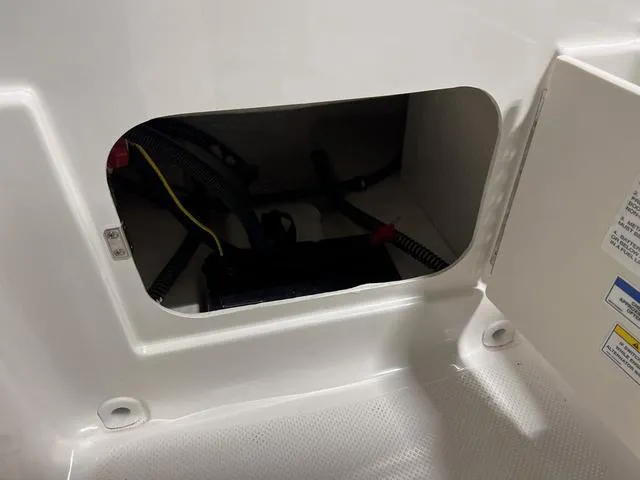 Slide: The Image of 2024 Bayliner E18 LTD storage compartment with wiring and battery. - 11